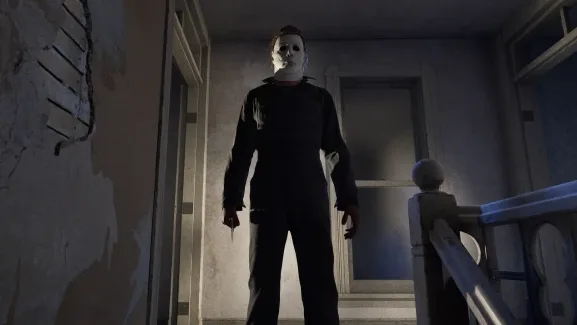 Michael Myers stalking a dimly lit hallway in Halloween The Game gameplay